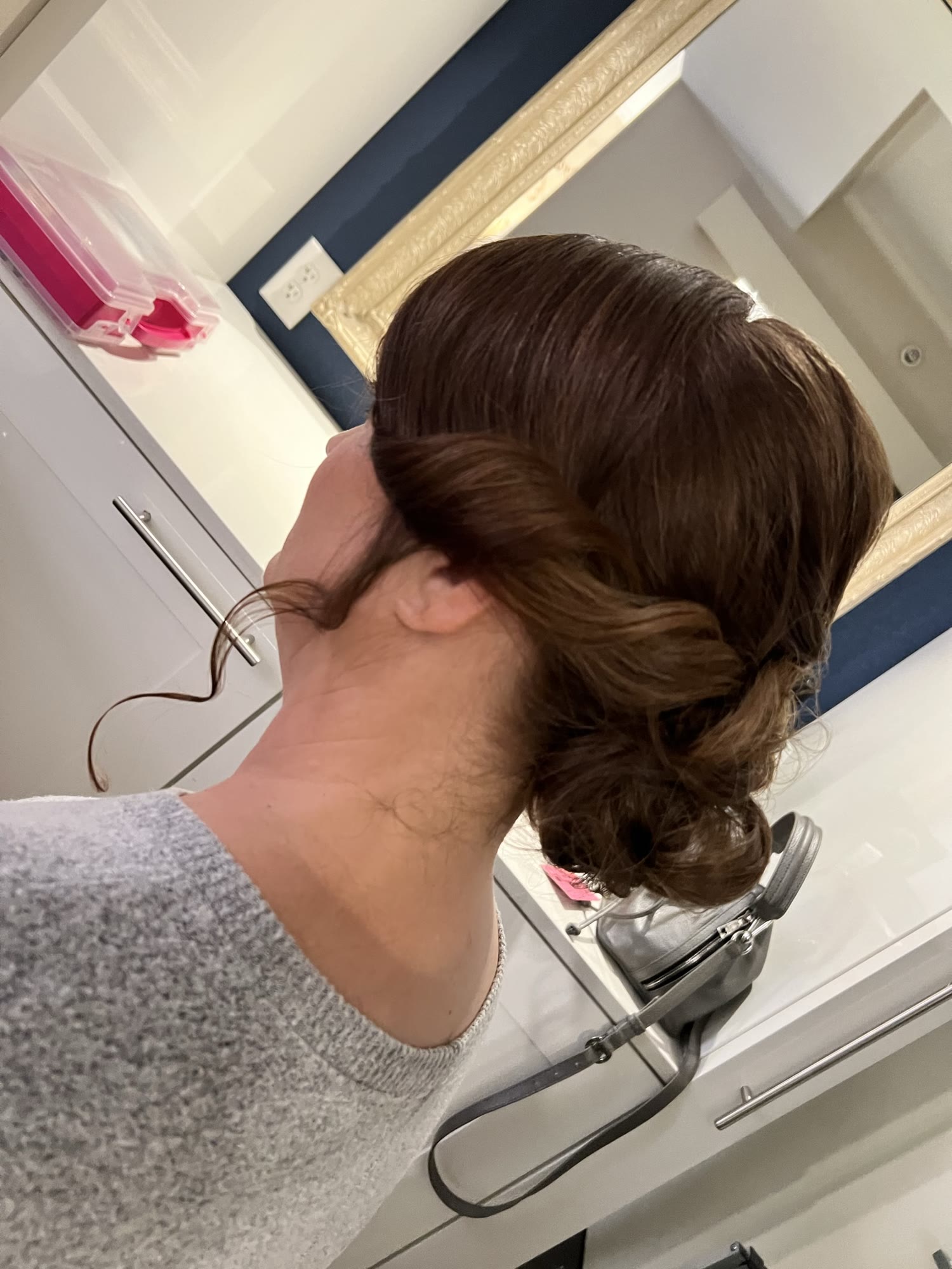 Low twisted bun with face-framing tendrils