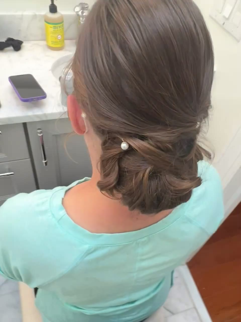 Sleek low ponytail with a pearl pin